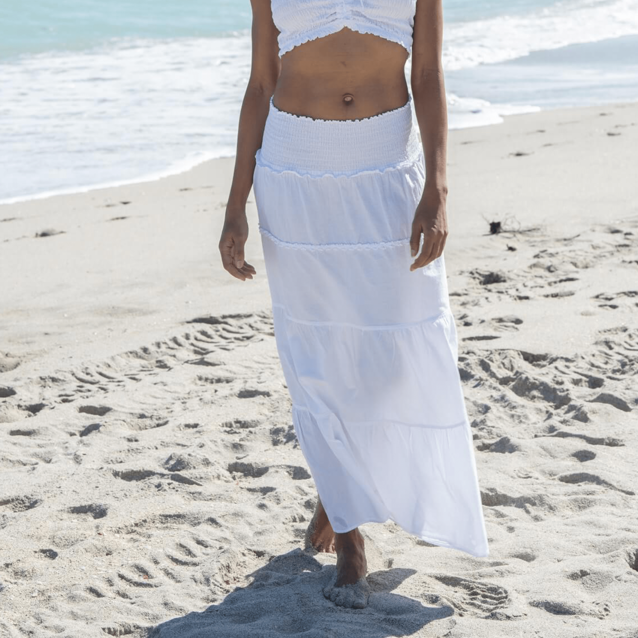 The Riviera Skirt featuring a long ruffle design, crafted from ultra-soft Cotton Natural fabric. This elegant skirt combines comfort and sophistication with a relaxed fit, making it perfect for both casual and dressed-up occasions.